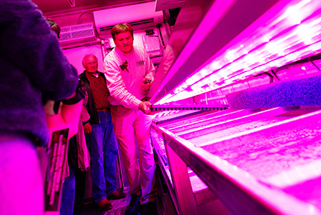 Dr. David Kopsell leads a tour, showcasing the workbench at the Vertical Farm at Illinois State University.