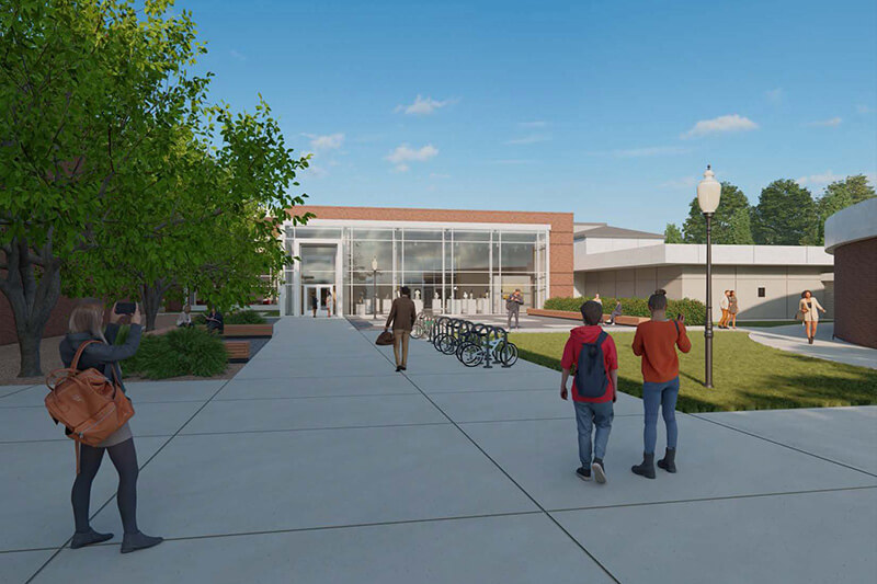 A digital rendering of a campus walkway leading to a modern building with a red brick and glass facade, with people walking and trees nearby.